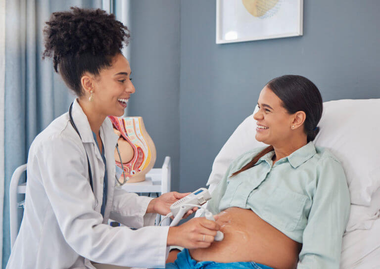 obgyn talking to her pregnant patient during prenatal care visit