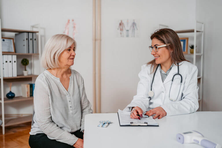 An elderly woman visits a women's health doctor’s office.